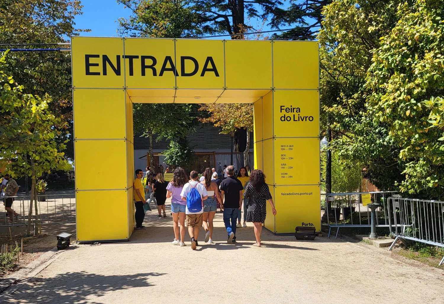 The yellow ENTRADA arch at the entrance of the Feira do Livro do Porto in the Jardins do Palácio de Cristal