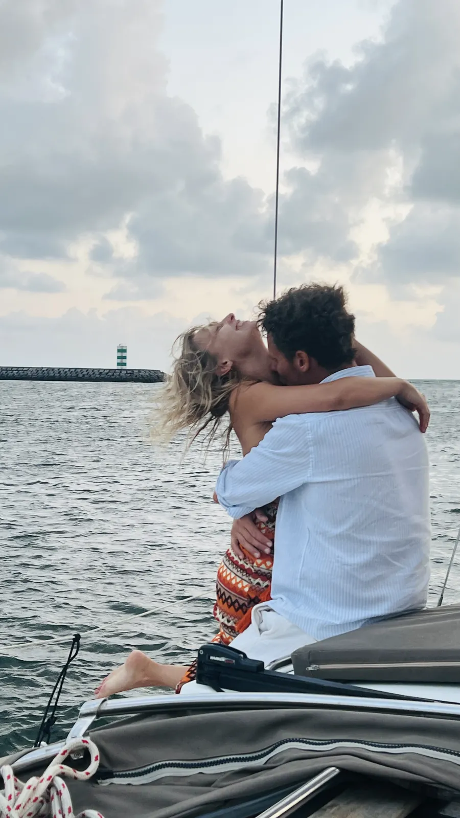 Casal a beijar-se no convés junto ao farol da Foz durante um cruzeiro ao pôr do sol no Porto