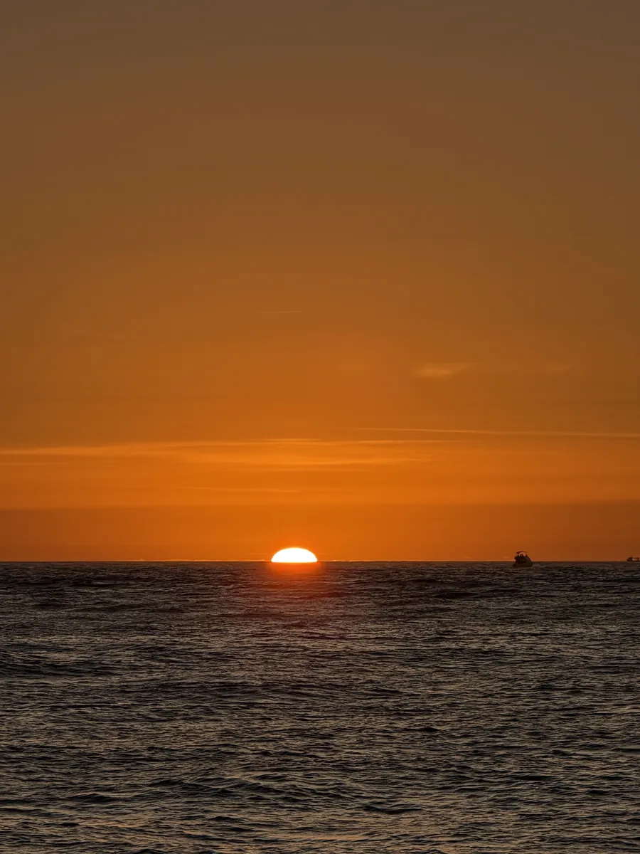 The sun setting on the Atlantic horizon, seen from the water off Porto